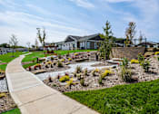 Thumbnail 35 of 42 - A residential area with a house, a garden, and a paved walkway.
