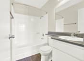 Thumbnail 20 of 23 - A white bathroom with a toilet, sink, and shower.