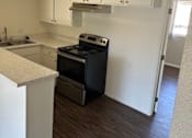 Thumbnail 11 of 19 - an empty kitchen with white cabinets and a black stove