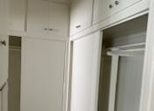 Thumbnail 25 of 35 - a walk in closet with white cabinets and
