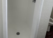 Thumbnail 24 of 35 - a white shower in a bathroom with a toilet