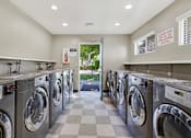 Thumbnail 4 of 29 - A row of washing machines in a laundromat.