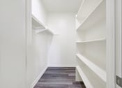 Thumbnail 10 of 29 - A long hallway with white shelves on the side.