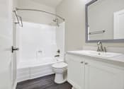 Thumbnail 7 of 29 - A white bathroom with a toilet, sink, and shower.