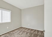 Thumbnail 23 of 29 - A room with a carpeted floor and a window with blinds.