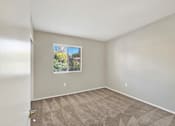 Thumbnail 20 of 29 - A room with a window and carpeted floor.