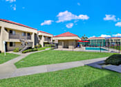 Thumbnail 10 of 23 - A sunny day at the apartment complex with a clear blue sky.