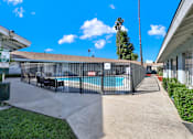 Thumbnail 4 of 35 - A pool surrounded by a black fence with a sign on the left.