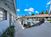 Thumbnail 7 of 35 - A residential area with a pool and a fence.