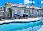 Thumbnail 3 of 35 - A pool with a blue tiled edge and a white fence.