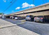 Thumbnail 15 of 35 - Cars parked in a parking lot under a clear blue sky.