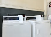 Thumbnail 16 of 35 - A white washing machine and dryer sitting next to each other.