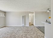 Thumbnail 20 of 27 - Spacious living room with ceiling fan and carpet at ELEVATE Apartments HOMES, California, 92870