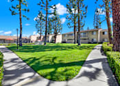 Thumbnail 6 of 27 - Courtyard with walking paths and green lawn at ELEVATE Apartments HOMES, Placentia