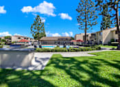 Thumbnail 7 of 27 - Outdoor pool area with landscaping and sundeck at ELEVATE Apartments HOMES, California