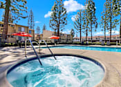 Thumbnail 9 of 27 - Hot tub and pool with surrounding seating at ELEVATE Apartments HOMES, Placentia, CA 92870