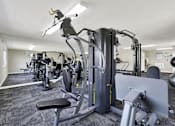 Thumbnail 10 of 20 - A gym with a variety of equipment including a leg press machine at THE STREAMS Apartments, Fullerton, 92831