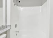 Thumbnail 20 of 20 - A white bathroom with a white tub and a white toilet at THE STREAMS Apartments, Fullerton, 92831