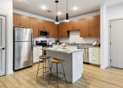Thumbnail 19 of 25 - a kitchen with a island and two stools at Gibson Oaks, Lakeland, 33809