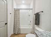 Thumbnail 17 of 25 - a bathroom with a shower and a toilet and a shower curtain at Gibson Oaks, Lakeland, 33809