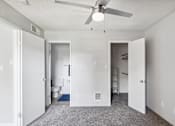 Thumbnail 13 of 32 - A white room with a ceiling fan and a toilet in the corner.