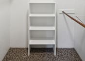 Thumbnail 14 of 32 - A white shelf unit with three shelves is in a white room.