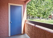 Thumbnail 18 of 32 - A blue door is on the left side of a concrete wall.