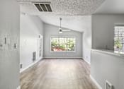 Thumbnail 5 of 32 - A spacious room with a window overlooking a garden.