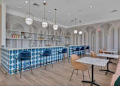 Thumbnail 44 of 57 - a Clubhouse with blue and white tables and chairs and a bar