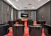 Thumbnail 55 of 57 - a conference room with leather chairs and a table with a television on the wall