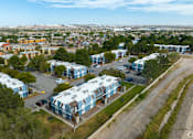 Thumbnail 27 of 28 - A view of a residential area with apartment buildings and cars parked in the driveways.