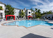 Thumbnail 18 of 44 - A swimming pool surrounded by a red canopy and a white building in the background.
