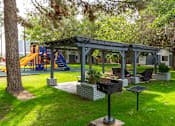 Thumbnail 18 of 28 - A playground with a slide and a gazebo.