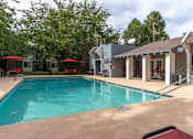 Thumbnail 15 of 28 - A swimming pool with a building in the background.