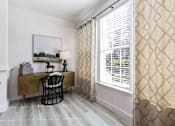 Thumbnail 8 of 50 - A room with a desk and chair in front of a window with blinds.