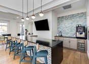 Thumbnail 35 of 50 - A kitchen with a black counter and blue chairs.