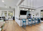 Thumbnail 34 of 50 - A kitchen with a bar and blue chairs.