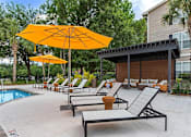 Thumbnail 20 of 50 - A poolside area with sun loungers and umbrellas.