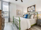 Thumbnail 13 of 50 - A bedroom with a green bed frame and a white bedspread.