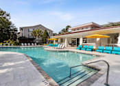 Thumbnail 17 of 50 - A swimming pool with a slide and sun loungers.