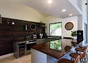 Thumbnail 30 of 32 - A kitchen with a wooden bar counter and stainless steel appliances.