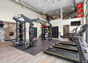Thumbnail 16 of 43 - A gym with a climbing wall, treadmills, and weights.