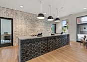 Thumbnail 19 of 43 - A reception area with a brick wall and a black and white reception desk.