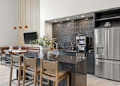 Thumbnail 22 of 43 - A modern kitchen with a bar area and stainless steel appliances.