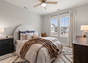 Thumbnail 35 of 43 - A bedroom with a large bed and a ceiling fan.