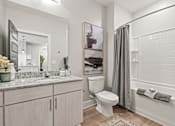 Thumbnail 43 of 43 - A bathroom with a toilet, sink, and a mirror.