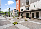 Thumbnail 10 of 43 - A courtyard with a brick patterned floor and a few potted plants.