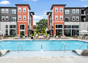 Thumbnail 5 of 43 - A swimming pool in front of apartment buildings.