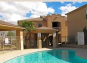 Thumbnail 9 of 18 - A pool in front of a building with a fence around it.