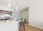 Thumbnail 9 of 57 - a kitchen with a white counter top and a bar with three stools
